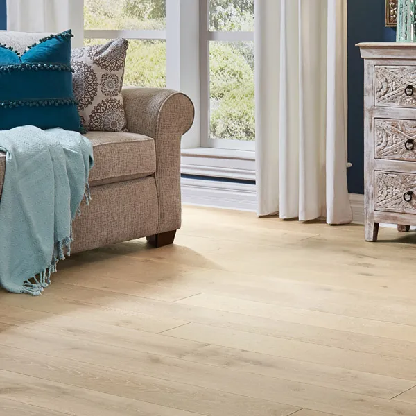 Living room scene - couch with pillows on light-colored wood-look floor.