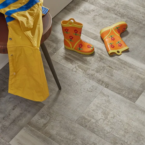 Entryway scene - raincoat draped on table, rain boots on waterproof LVP floor.